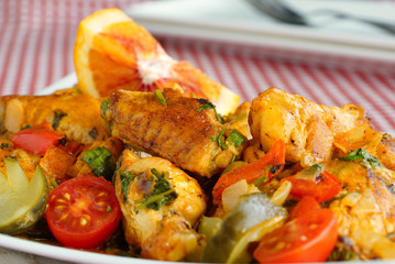 Braised chicken wings with orange and pickled cucumber.