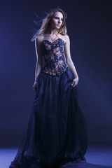 Portrait of a woman in a beautiful dress with a floral pattern in the Studio