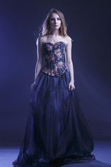 Obraz premium Portrait of a woman in a beautiful dress with a floral pattern in the Studio