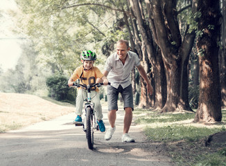 Obraz premium Father help his son learn to ride bicycle