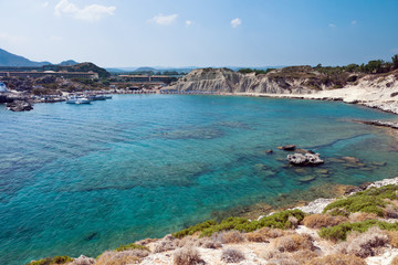Fototapeta na wymiar Kolymbia beach with boat and the rocky coast in Greece.