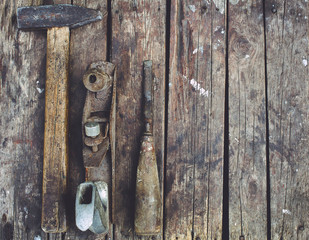 Old woodworking tools lie on a wooden surface. Hammer, planer, c