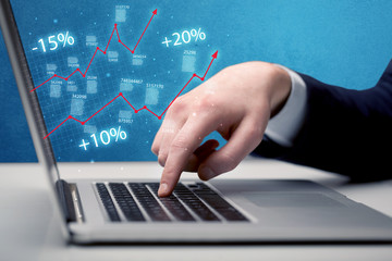 Salesman working on graph with laptop