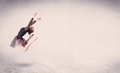 Modern ballet dancer performing art jump with empty background
