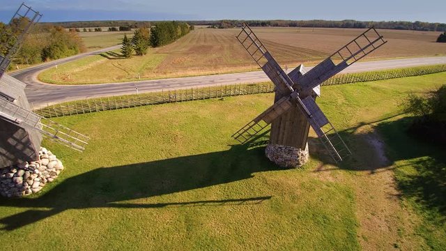 The old windmill on the small farm in a town in Angla where the field is just across the road and the small farm house