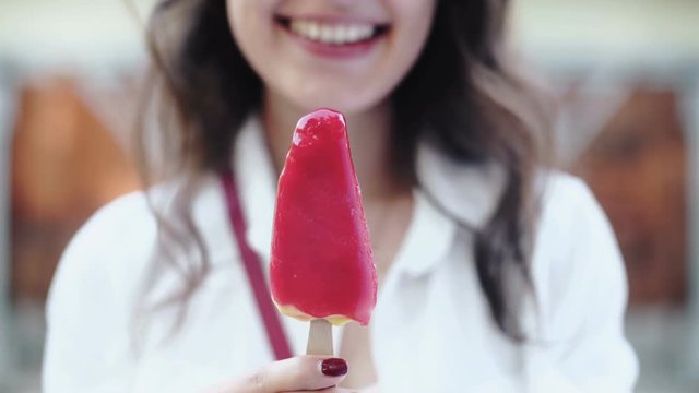 Portrait of young happy woman eating ice-cream, outdoor