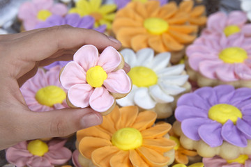 Young hand holding home made designer Flower Sugar cookies