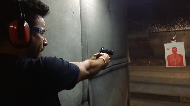 Slow motion of man practicing shooting at gun range