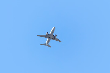 Fototapeta na wymiar One airplane taking off on blue sky background