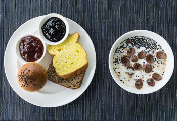 Closeup Bread with homemade jam. Bowl of cereal. Breakfast meal. Top view.