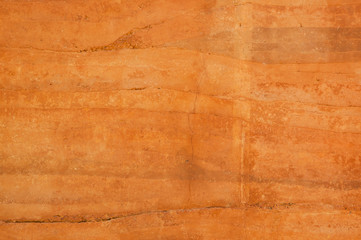 Rammed earth wall with different shades of orange soil