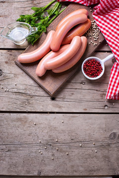 Sausages on board  with herb and spices on aged  wooden backgrou