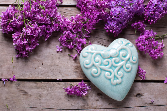 Violet lilac flowers and  turquoise decorative heart on aged  wo