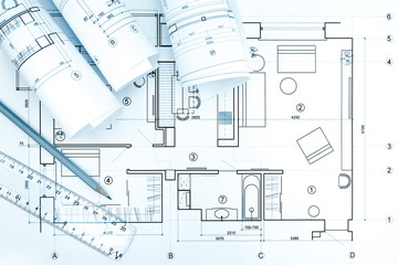 architectural blueprint rolls with plan, pencil and ruler