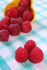 Fresh raspberries on checkered tablecloth, healthy food