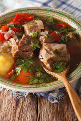 Shurpa lamb soup with vegetables closeup on the table. Vertical

