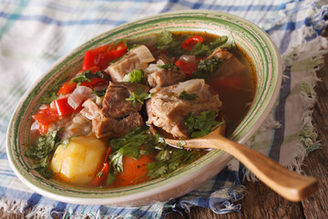 Shurpa lamb soup with vegetables closeup on the table. horizontal
