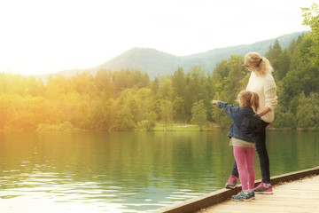 Fototapeta premium Mother and daughter enjoying the view on a lake.