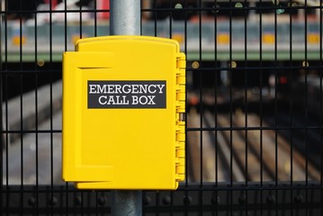 Yellow emergency call box at a fence of construction site