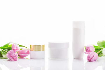 empty tubes of cream on a white background with tulips