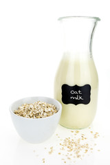 Oat milk and oatmeal in bowl,  on white background
