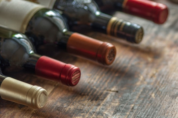 Row of wine bottles on wooden background. Low depth of field.  - Powered by Adobe