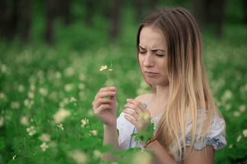 Beautiful young girl close-up in a white shirt, against a background of green forest