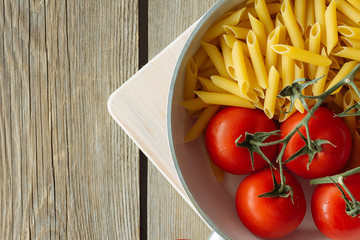 Pasta and tomatoes in the pot top view