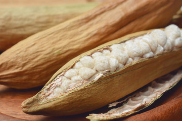 white cotton from dry kapok fruit. cotton and kapok fruit on wooden plate.