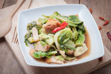 Fried Oyster sauce vegetables sect with crispy pork on wood floo