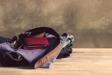 Naklejka premium Vintage,Jean,T-shirt,sunglasses,Belt,Wallet on wooden table back