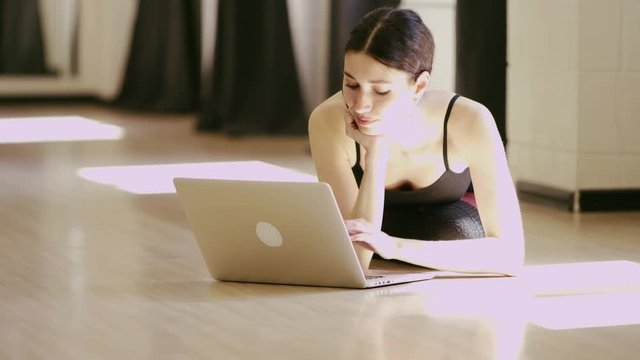 beautiful girl wearing ballet leotard with laptop