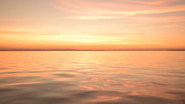 Beautiful calm ocean at sunset POV from a moving boat