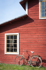 Fototapeta na wymiar Vintage bicycle leaning against a red colored wooden house