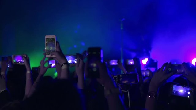 Making party at a rock concert and hold cameras with digital displays