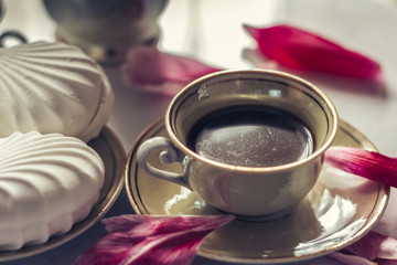 Obraz na płótnie Canvas Coffee cup with marshmallows and peony petals