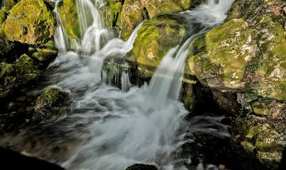 Source of the river that makes waterfalls over rocks covered wit
