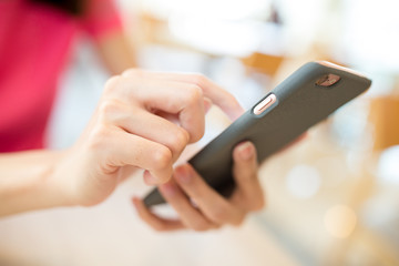 Woman surfing internet on mobile phone in coffee shop