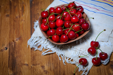 Fresh cherries in bowl on table