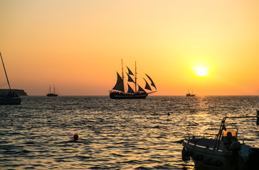 парусник в море на фоне заката  