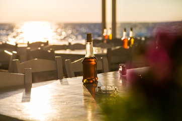 Бутылочка с маслом на фоне заката 