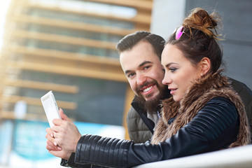 Young couple texting in city