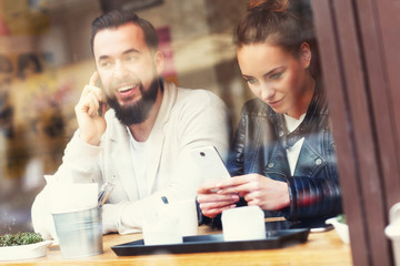 Happy couple using phones