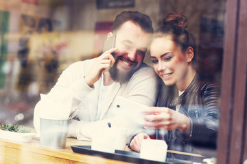Happy couple using phones