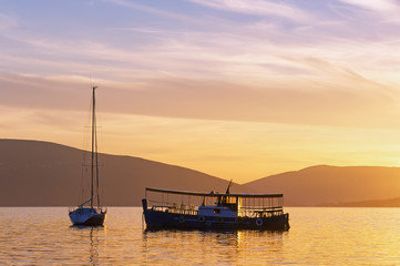 Fototapeta na wymiar Silhouettes of two boats at sunset. Bay of Kotor, Montenegro