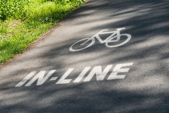 In-line and bike lane track sign black white asphalt grass text
