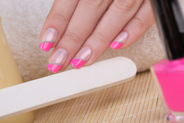 Manicure - Beauty treatment photo of nice manicured woman fingernails. Very nice pink French manicure with silver detail.