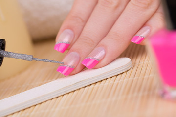 Manicure - Beauty treatment photo of nice manicured woman fingernails. Very nice pink French manicure with silver detail.