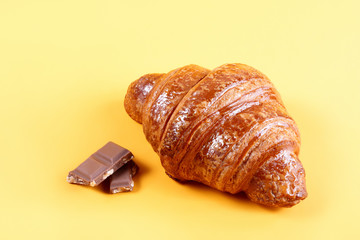 Tasty croissant with chocolate and jam on yellow background
