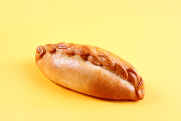 Fresh pie, bun with meat and vegetables on yellow background. Pastries and bread in a bakery